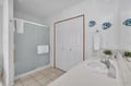 Freshen up in your bright, cheerful bathroom with a spacious walk-in shower, crisp white towels, and coastal charm that makes every morning feel like a beach getaway.
