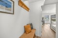 Step into your bright coastal retreat, where warm wooden accents and beachy artwork welcome you home after a day of exploring.