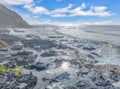 Dramatic coastline with rocky tide pools and crashing waves beneath towering cliffs creates a stunning natural backdrop for the property.
