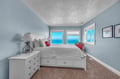 Wake up to stunning ocean views from your serene coastal bedroom, where calming blue walls and crisp white linens create the perfect seaside retreat.