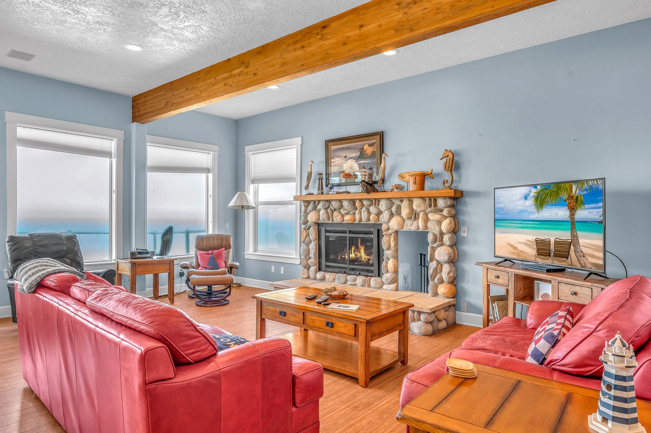 Sink into plush red leather sofas by your crackling stone fireplace, where exposed beams and lake views create the perfect retreat.