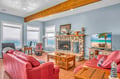 Sink into plush red leather sofas by your crackling stone fireplace, where exposed beams and lake views create the perfect retreat.