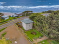 Coastal property located steps from the beach, offering direct ocean access and lush green surroundings with scenic natural landscape views.