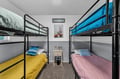 Bright, spacious bunk room with colorful bedding—perfect for families or groups traveling together. Each bed offers a cozy retreat after a fun-filled day.