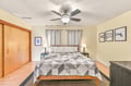 Drift off in this serene bedroom where soft lighting and coastal artwork create your personal retreat. A ceiling fan keeps the air fresh, while crisp bedding and thoughtful touches invite restful nights after your adventures.