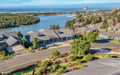 Stunning aerial view of coastal neighborhood with river winding toward the ocean, showcasing Pacific Northwest natural beauty.