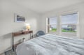 Wake up to the soft glow of natural light streaming through your bedroom windows. Sink into the plush comfort of your bed and savor a peaceful retreat framed by quiet coastal charm.
