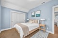 Unwind in your peaceful bedroom featuring calming blue walls, crisp linens, and modern coastal artwork that creates the perfect serene retreat.