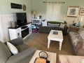 Sink into comfortable seating where you'll unwind with loved ones in this charming living space, complete with entertainment and thoughtful coastal touches.