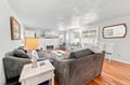 Settle into plush sofas in this sun-filled living space where natural light pours through beautiful windows. Your cozy evening conversations flow seamlessly from the inviting fireplace to the elegant dining area beyond.