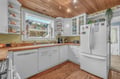 Your bright kitchen features wood countertops, white cabinets, and a cozy wood-beamed ceiling for memorable meal preparations.