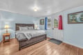 Your cozy bedroom features warm wood floors and a rustic bed with soft linens, perfect for peaceful nights after mountain adventures.