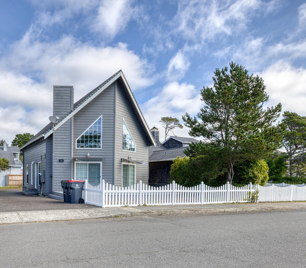 A charming coastal home nestled in a peaceful neighborhood, featuring classic architecture and lush surrounding greenery, perfect for your seaside getaway.
