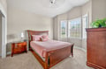 Slip into this cozy bedroom where rich cherry wood furniture creates a warm, elegant retreat for your peaceful nights.