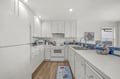 Whip up your favorite meals in this bright, fully-equipped kitchen featuring crisp white cabinetry, modern appliances, and coastal-inspired blue accents. Ample counter space awaits your culinary adventures.