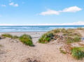 Pristine coastal landscape with natural dunes and rolling waves creates a peaceful beachfront setting.