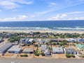 This beachfront vacation rental is located in a peaceful coastal neighborhood, just steps from the sandy shore and rolling ocean waves.