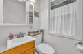 Freshen up in your private bathroom featuring a clean vanity, mirror, and natural light from the window.