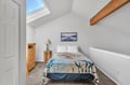 Sleep under the stars in this bright loft bedroom, where natural light streams through your skylight and rustic beams create cozy charm.