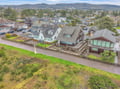 Coastal neighborhood with charming homes nestled among rolling hills and mature trees, offering a peaceful retreat setting.