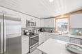 Your bright, modern kitchen features stainless steel appliances and crisp white cabinetry, with ample counter space for preparing meals and gathering with loved ones.
