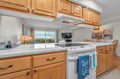 Your spacious kitchen features warm wood cabinets, granite counters, and modern appliances—perfect for preparing meals with scenic views beyond.