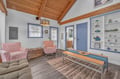 Step into your charming living space with exposed wood beams, cozy seating, and coastal décor that invites you to unwind in style.