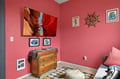 Unwind in your cozy living room with vibrant coral walls, stunning canyon artwork, and nautical touches creating a warm, welcoming atmosphere.