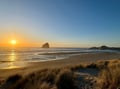 Stunning sunset views illuminate the pristine coastline with golden light reflecting off gentle waves and dramatic rock formations.
