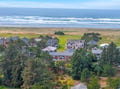 Coastal community nestled between lush greenery and pristine beach, offering peaceful retreat near rolling waves.