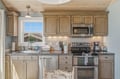 Your vacation kitchen blends warm wood tones with modern appliances, offering everything you need to prepare delicious meals while enjoying natural light and thoughtful design details throughout.