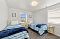 Two comfy twin beds await, each dressed in soft coastal hues that invite restful nights. Natural light fills your room, creating a bright and cheerful space to recharge after beachside adventures.
