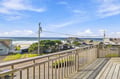 This coastal property sits in a charming beach neighborhood with direct ocean access and panoramic views across sandy shores and rolling surf.