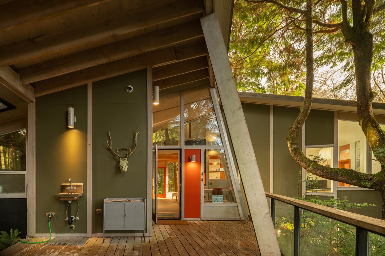 Step onto your private deck surrounded by lush trees, where modern design meets nature's tranquility in this stunning architectural retreat.