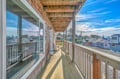 Step onto your private wraparound balcony where coastal charm meets comfort, offering panoramic neighborhood views beneath an expansive pergola ceiling.