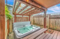 Slip into your private hot tub beneath the covered patio, where warm water and string lights create a cozy retreat no matter the weather.