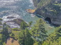 Dramatic coastline featuring turquoise waters, hidden sea caves, and lush green vegetation along rocky cliffs near the property area.
