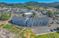Aerial view of the coastal property showcasing its prime location within the charming community, surrounded by forested hills and local amenities.