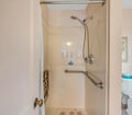 Step into your private bath, where a handheld showerhead and thoughtful grab bars ensure comfort and ease during your stay.