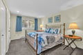 Sink into ocean-themed comfort in your serene bedroom, where nautical blues and warm lighting create the perfect coastal retreat for restful nights.
