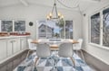 Gather around your modern dining table beneath warm pendant lighting, with large windows framing peaceful neighborhood views.