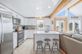 Bright, open kitchen with natural wood beams and a breakfast bar invites you to gather and create memories together. Stainless appliances and abundant natural light make cooking a joy.