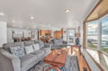 Relax on plush gray sofas while waves crash just outside your floor-to-ceiling windows in this bright, open living space.