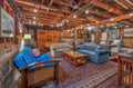 Unwind in your private basement retreat with exposed beams, cozy seating, and warm string lighting creating the perfect atmosphere.