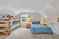 Your cozy attic bedroom features both a double bed and bunk beds, perfect for families. Soft lighting and blue linens create a peaceful retreat.