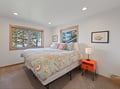 Wake up to snowy mountain views through your bedroom windows, where colorful ocean-themed bedding adds cheerful contrast to winter's tranquil beauty outside.