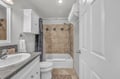 Step into your private bathroom featuring elegant travertine tilework, crisp white cabinetry, and fresh towels waiting for your arrival.