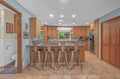 Gather around the breakfast bar in this bright, open kitchen where morning coffee and conversation flow easily. Gleaming granite counters and warm wood cabinetry create the perfect backdrop for your vacation meals.