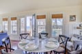 Picture yourself gathering around this charming dining table as sunlight streams through the windows, where meals become memorable moments with stunning water and neighborhood views as your backdrop.