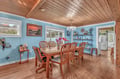 Gather around this welcoming dining table beneath stunning wood ceilings, where coastal blues and warm nautical touches create the perfect space for your meals together.